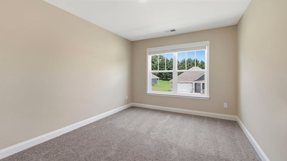 Bedroom with carpet and window.