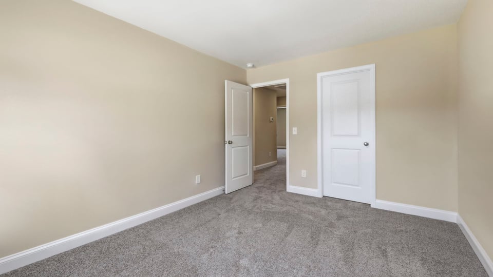 Bedroom with carpet and window.
