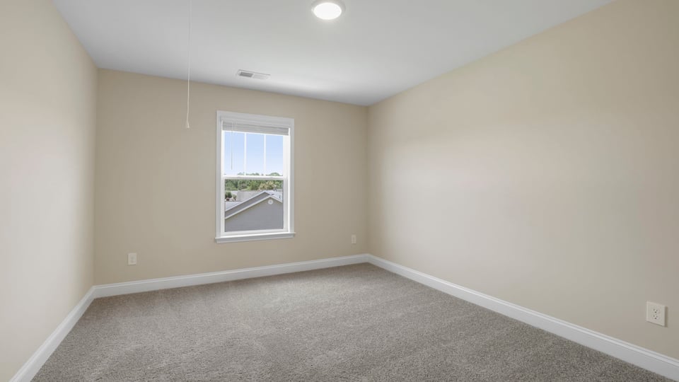 Bedroom with carpet and window.