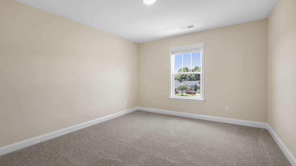 Bedroom with carpet and window.