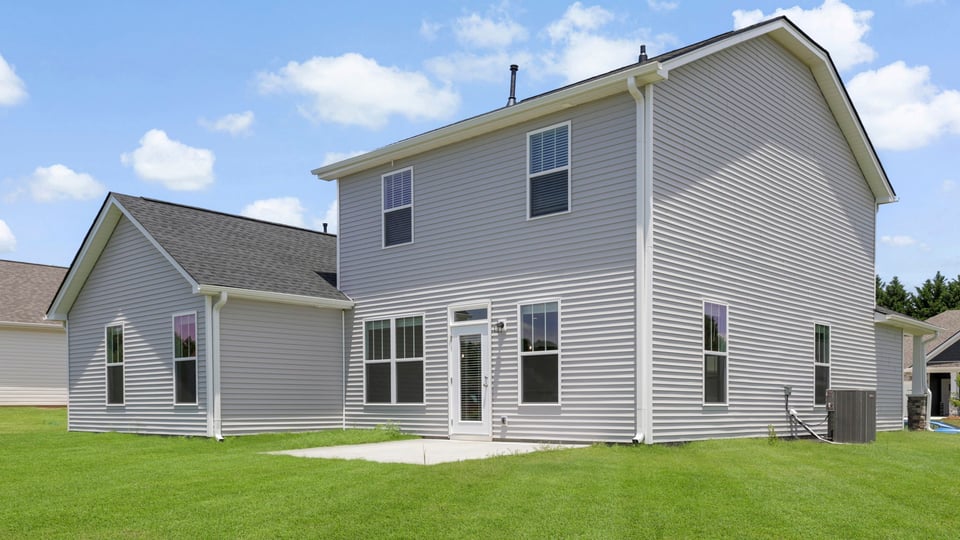 Back exterior of home with large backyard.