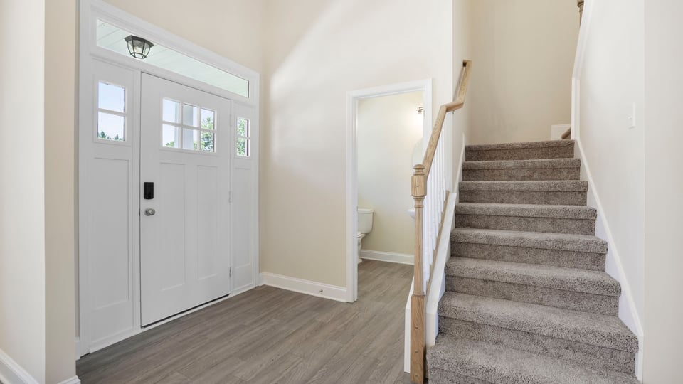 View of stairs and front door.