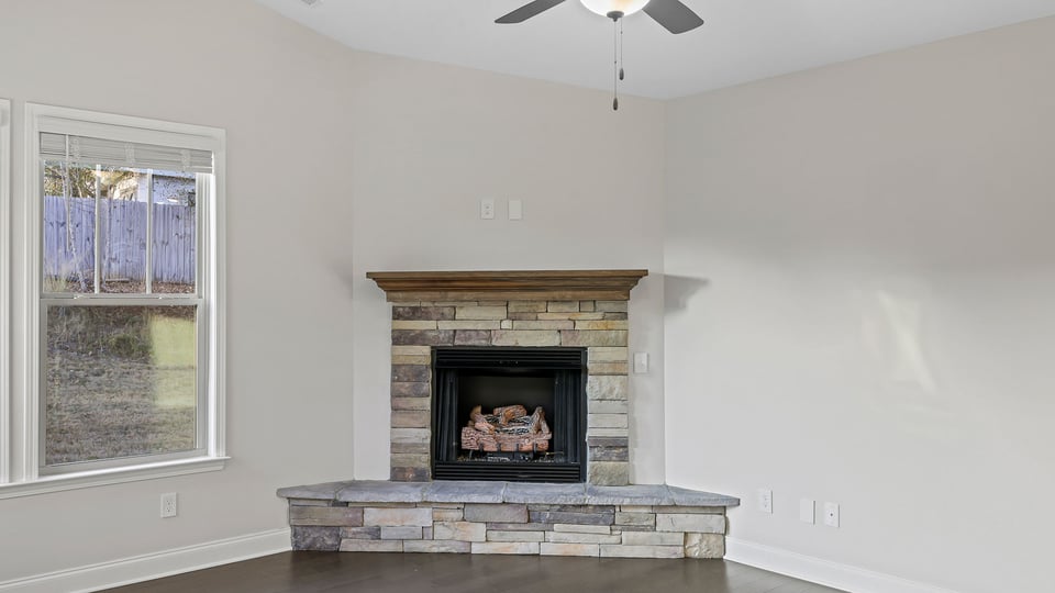 Gas log fireplace with raised stone hearth.