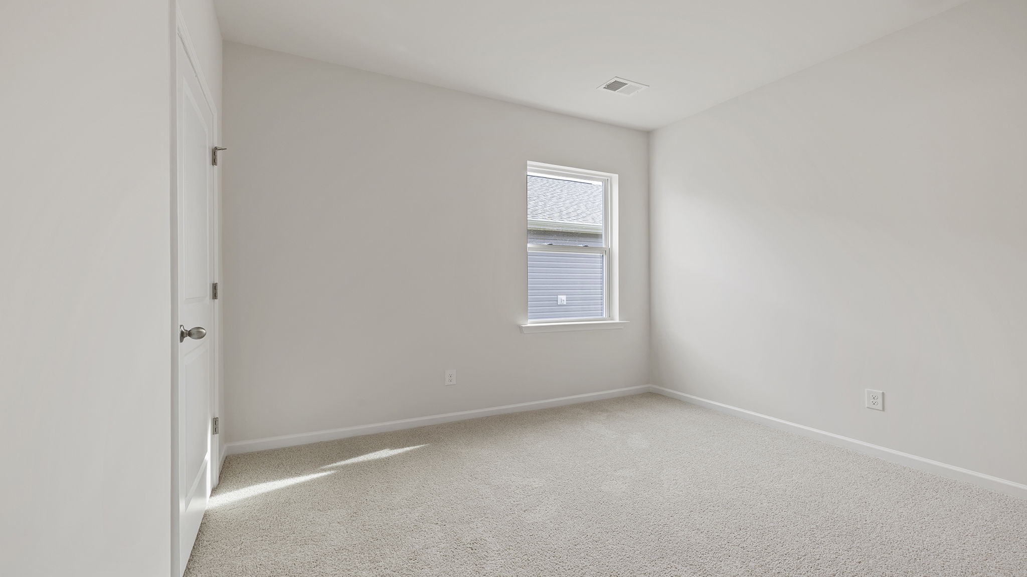 Bedroom with windows and carpet.