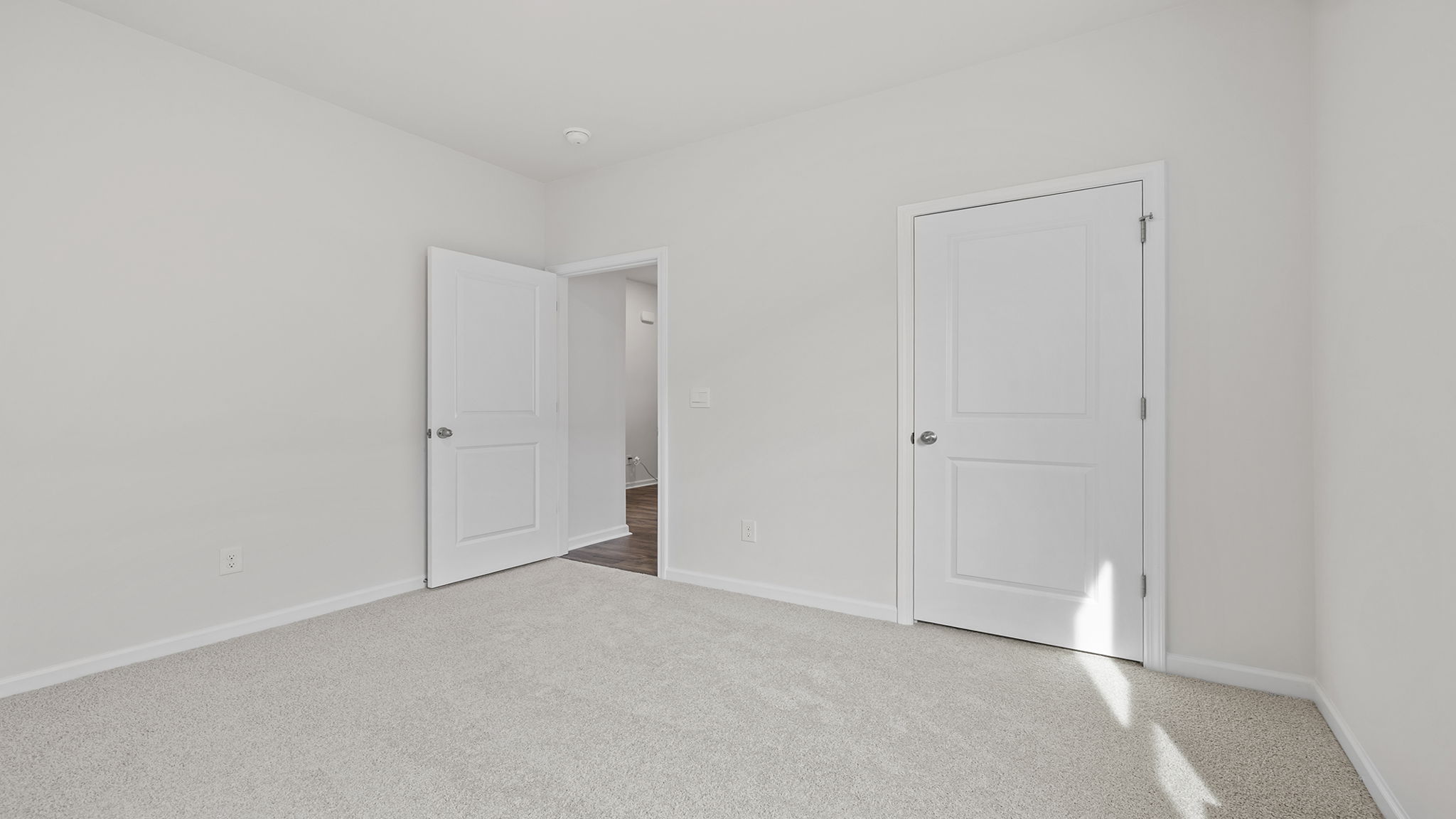 Bedroom with windows and carpet.