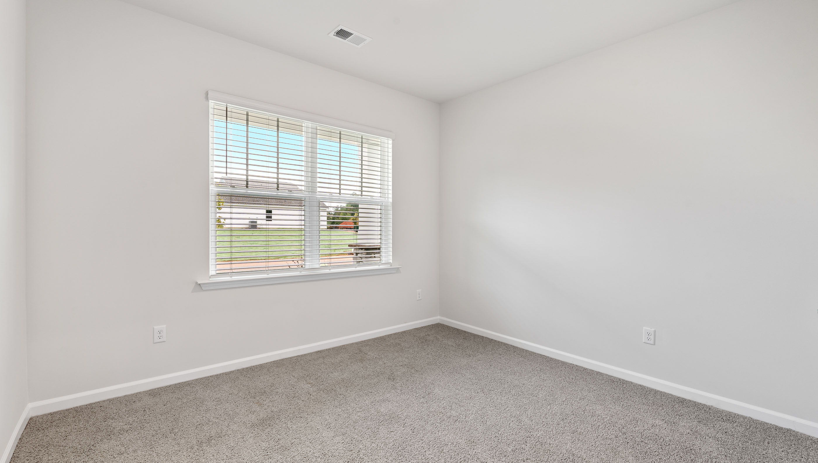 Bedroom with carpet and windows.
