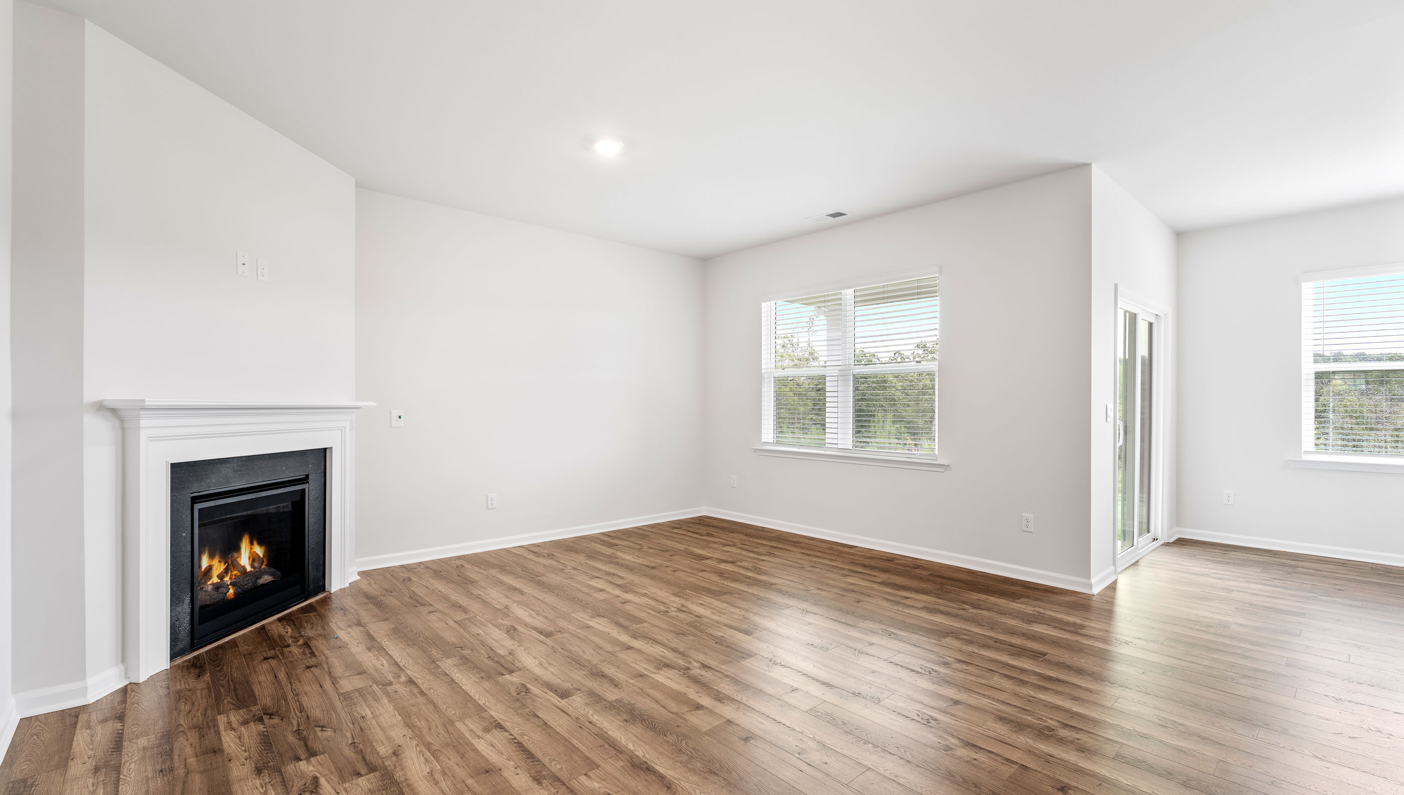 Family room with large windows and gas log fireplace.