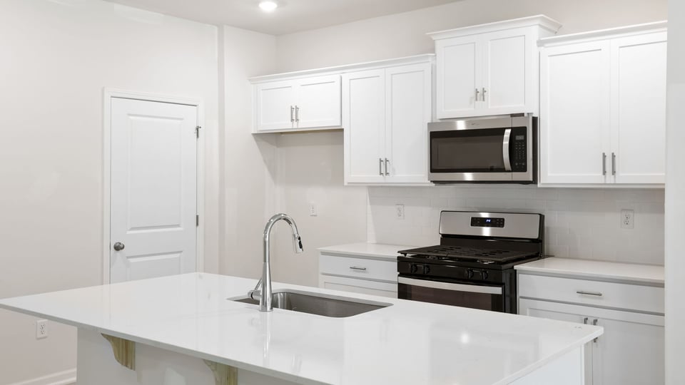 Kitchen and island with quartz countertops.