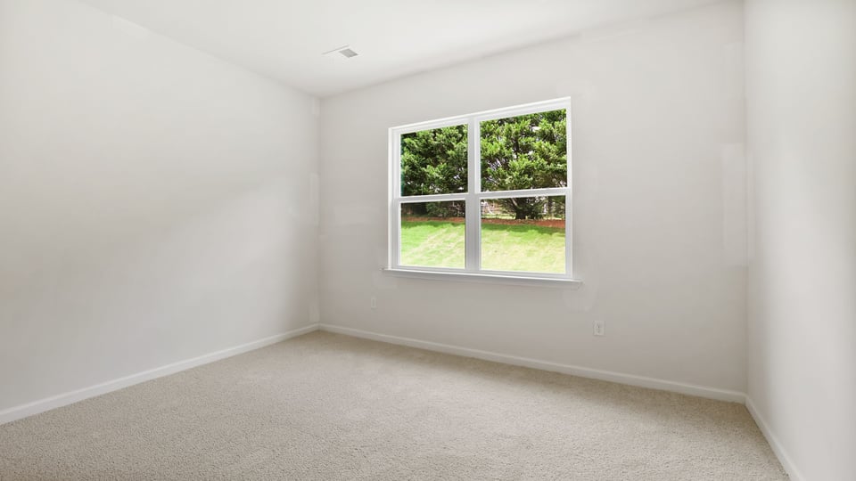Bedroom with carpet and window.