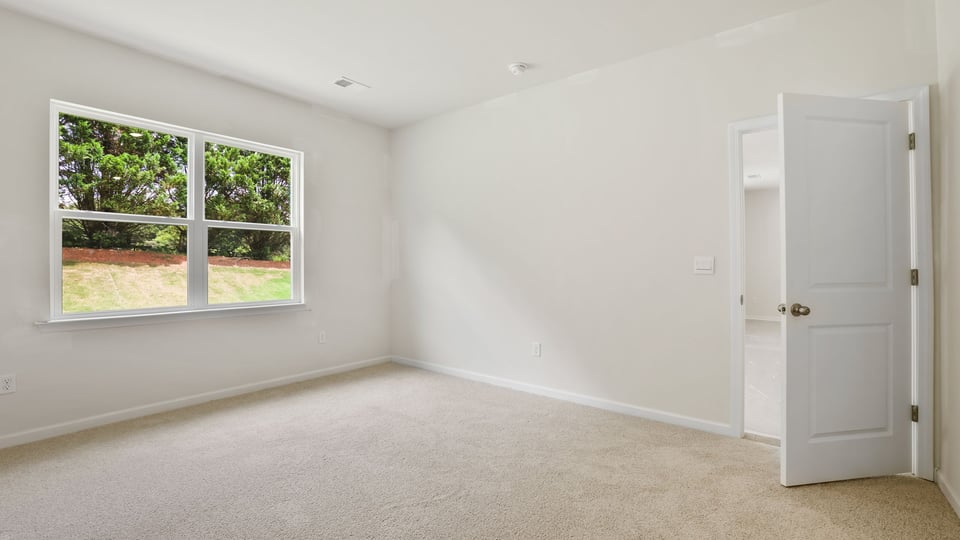 Bedroom with carpet and window.