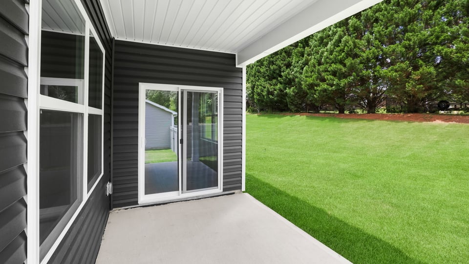 Back exterior of home with small patio.