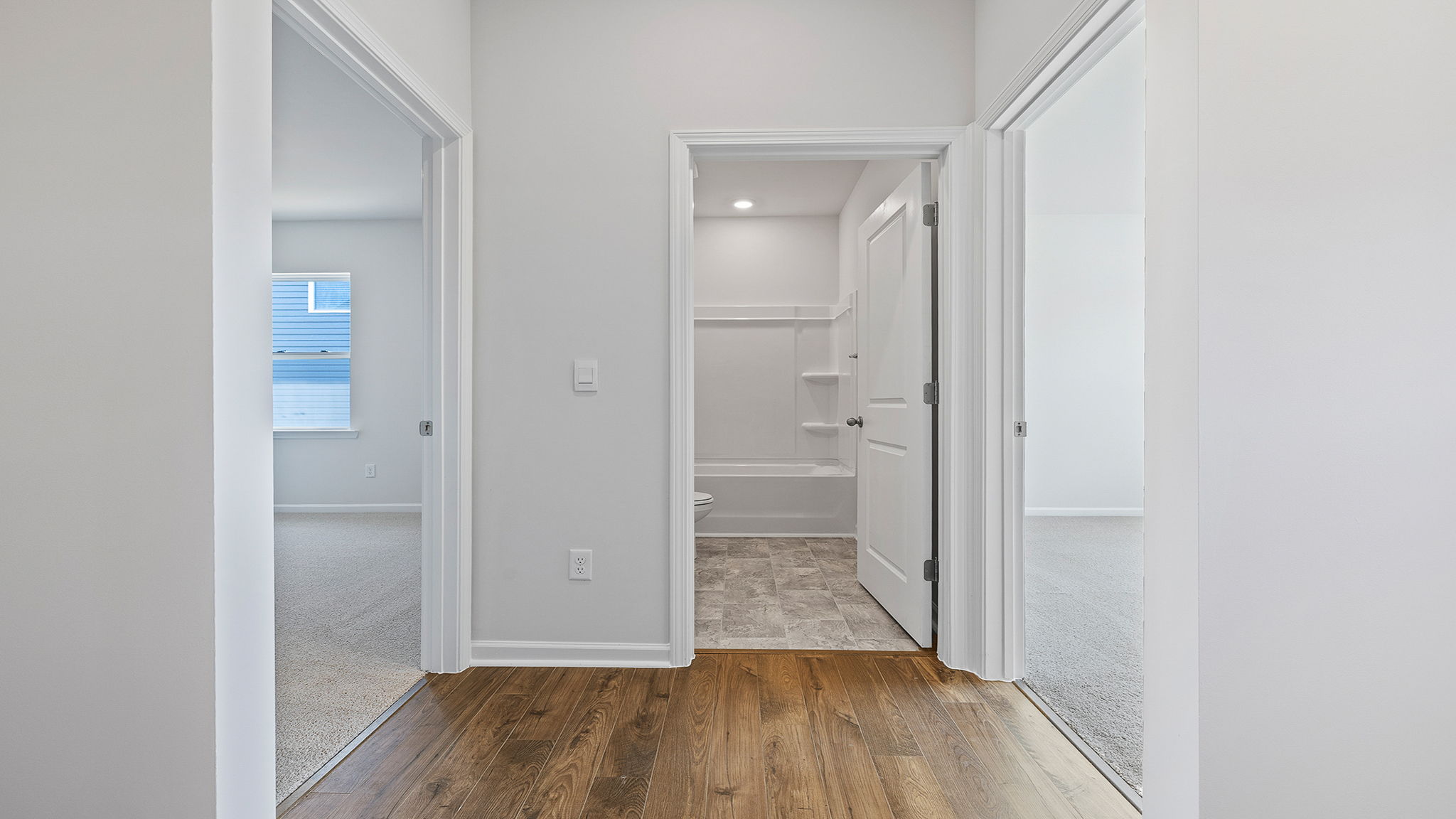 View of hallway bathroom and entrance to two bedrooms.