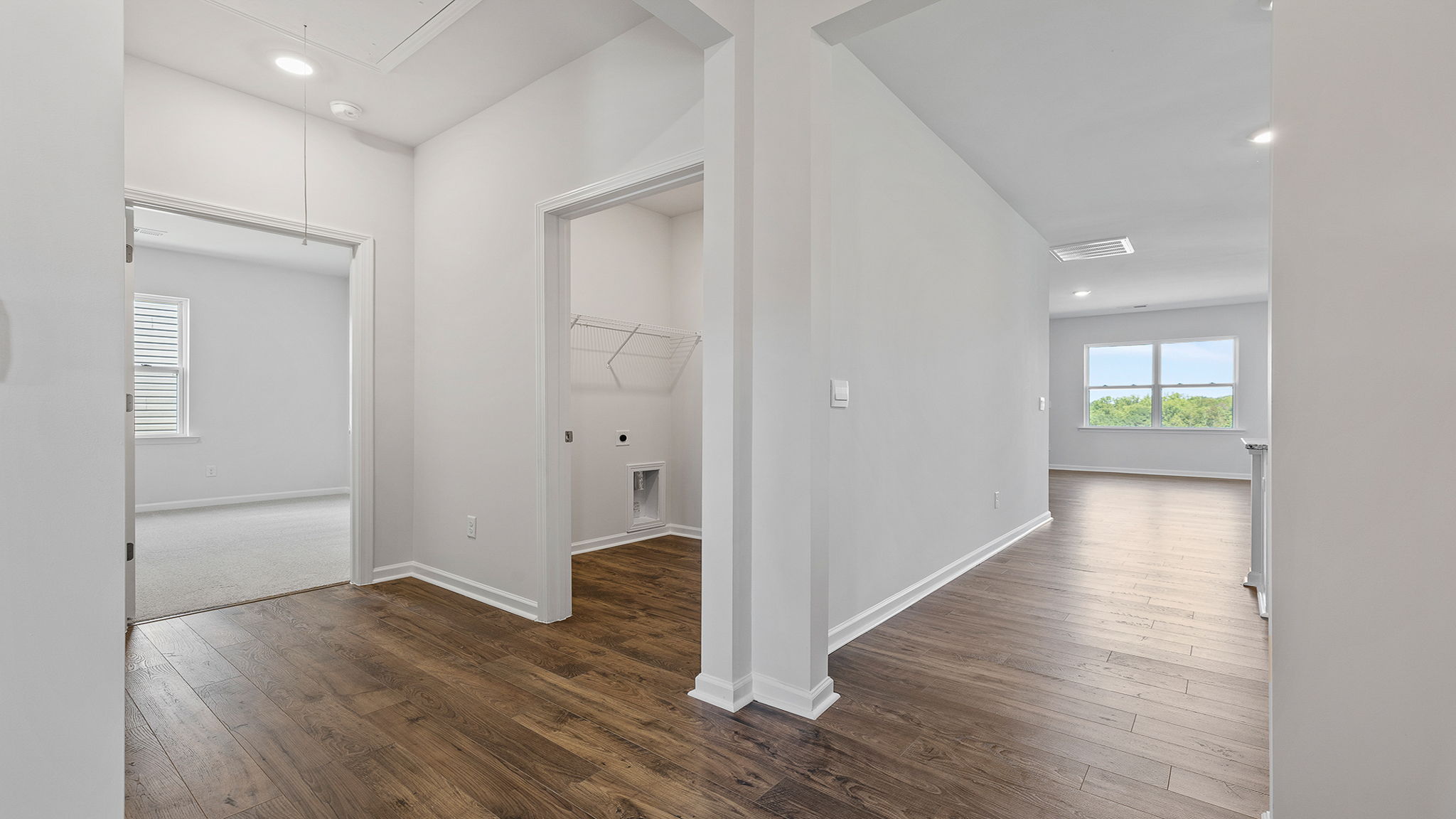 View of hallway noting the laundry room location and third bedroom entrance.