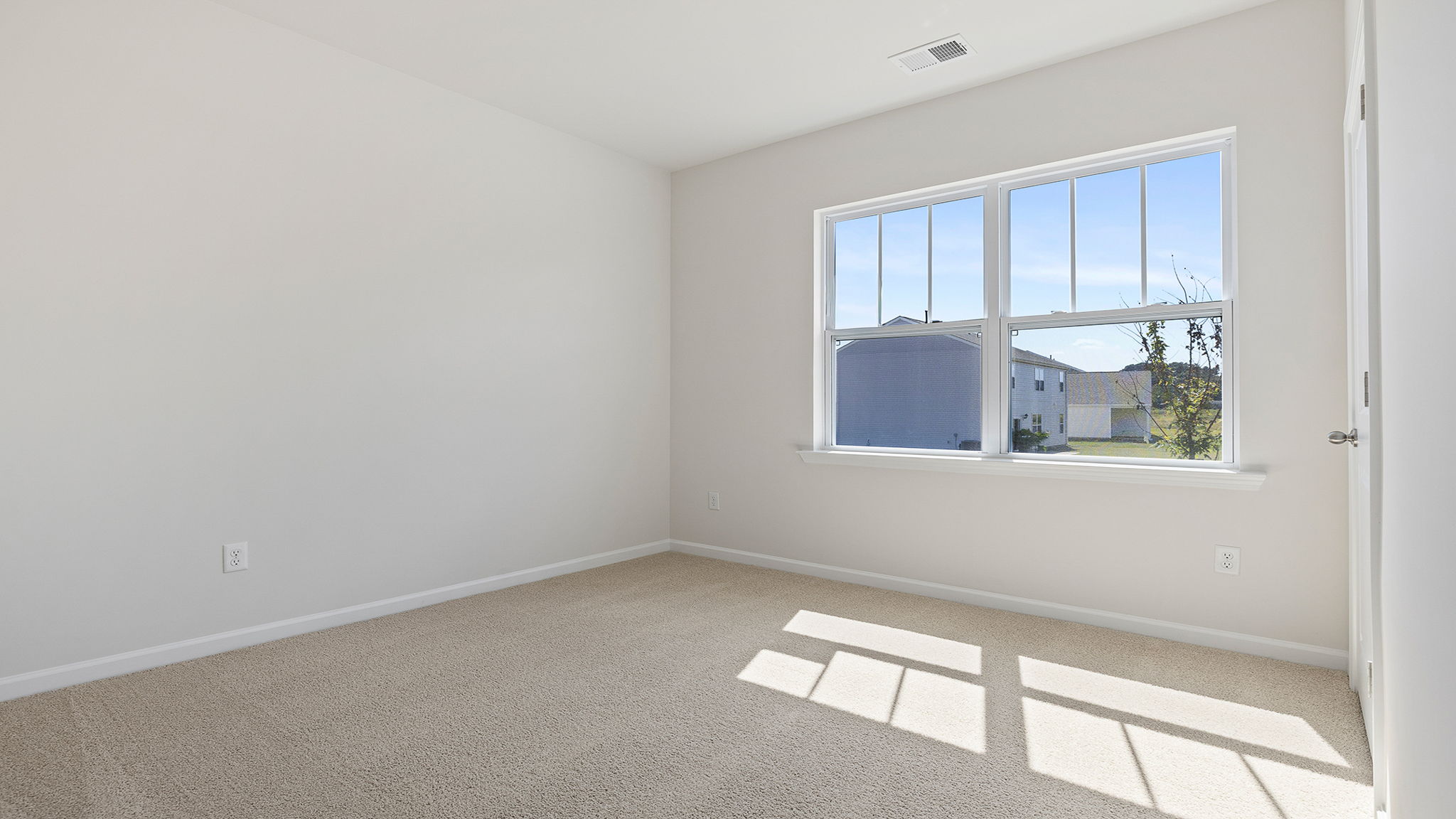 Bedroom with large window and carpet.