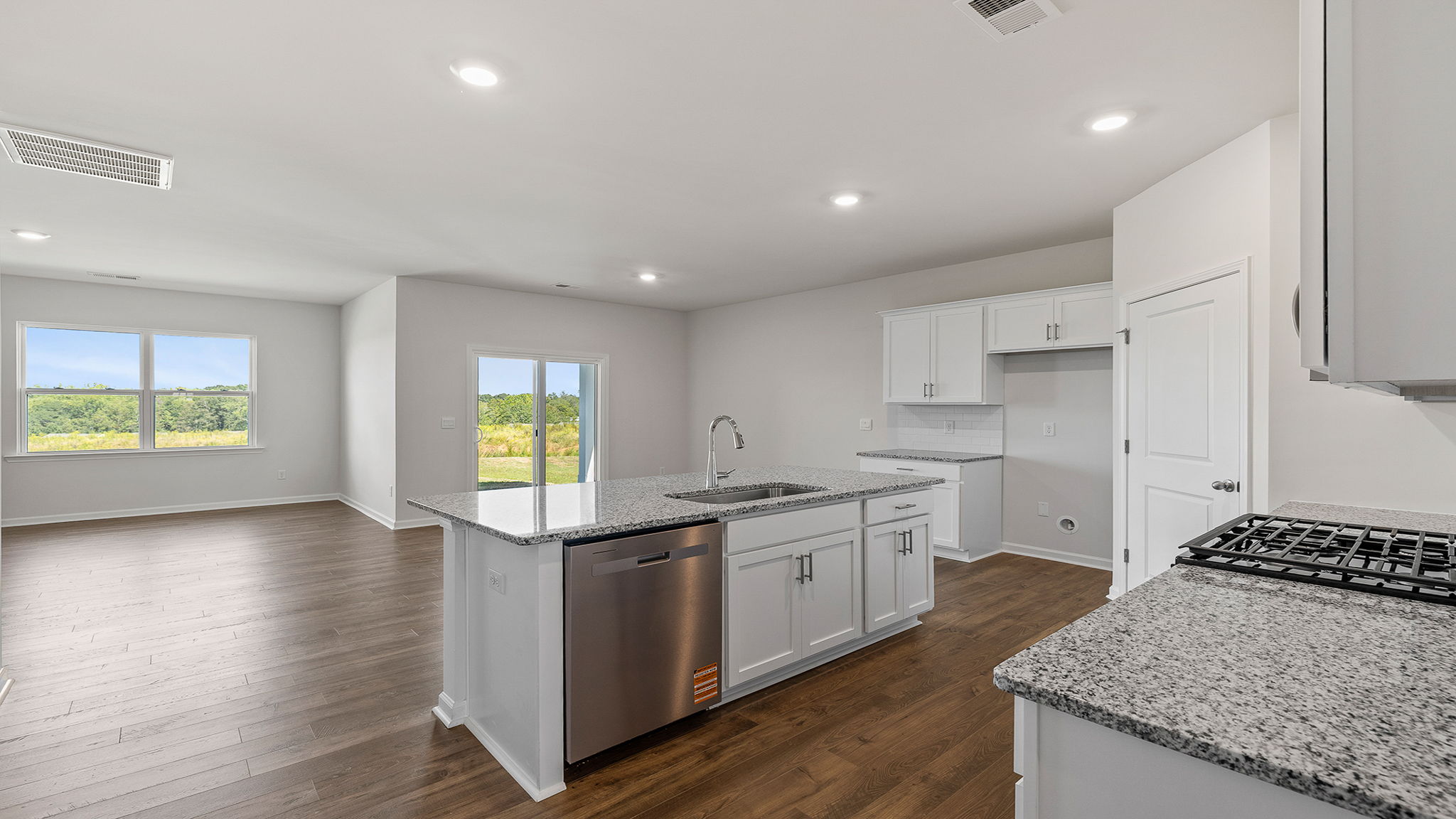 View of kitchen and open floor plan with lots of windows.