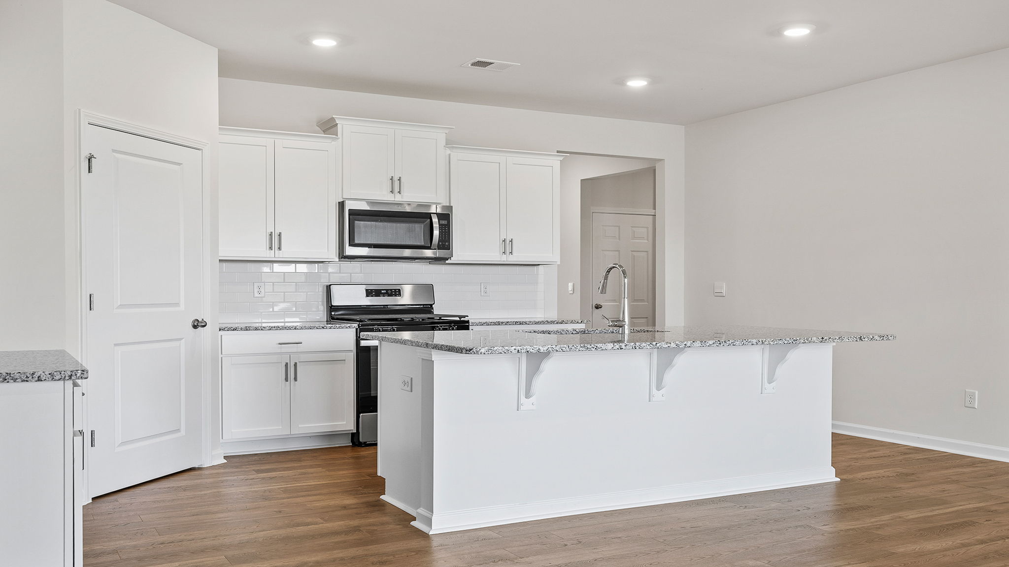 Open kitchen and island have quartz countertops.