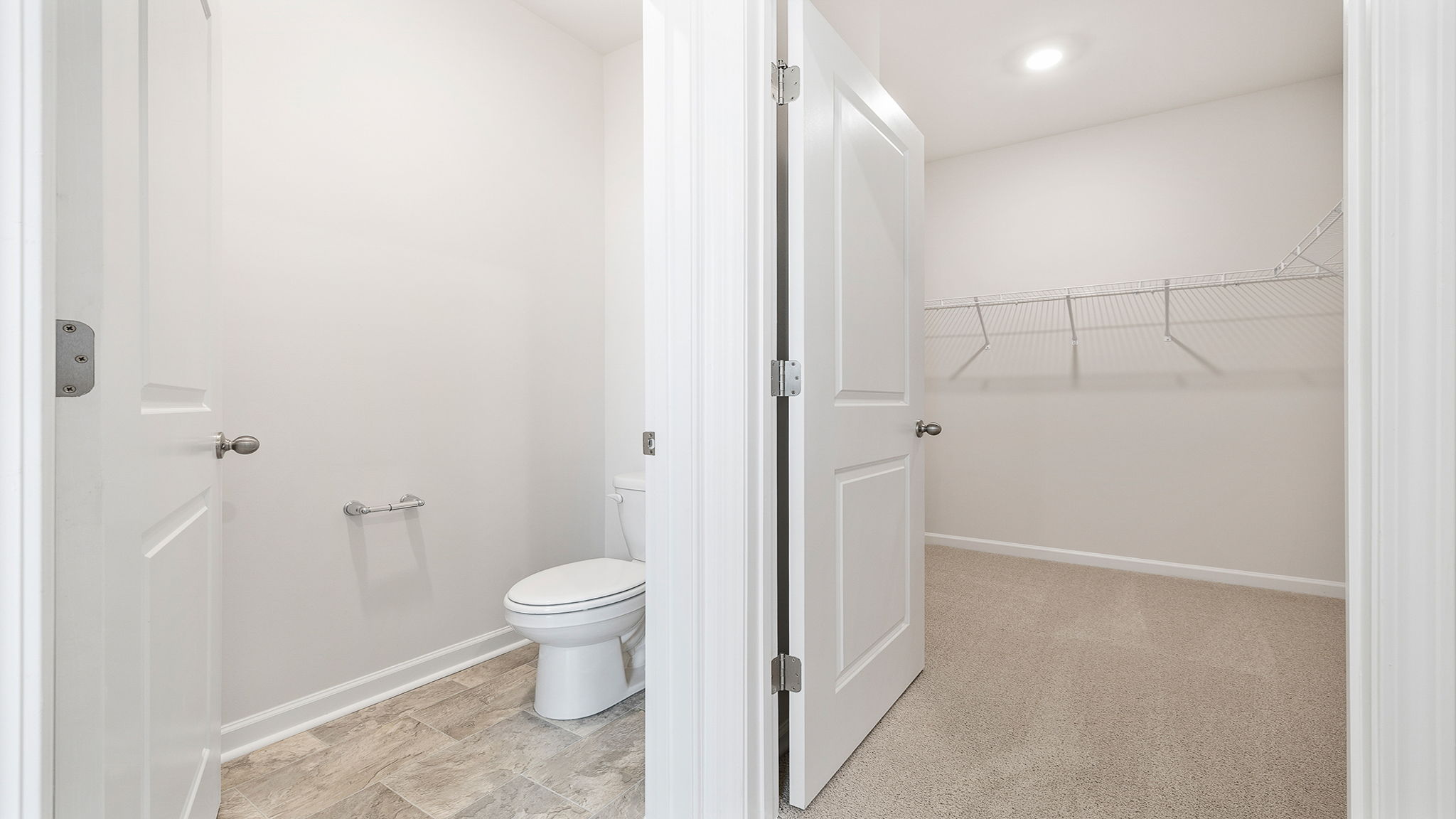 View of water closet and primary bedroom walk-in closet.