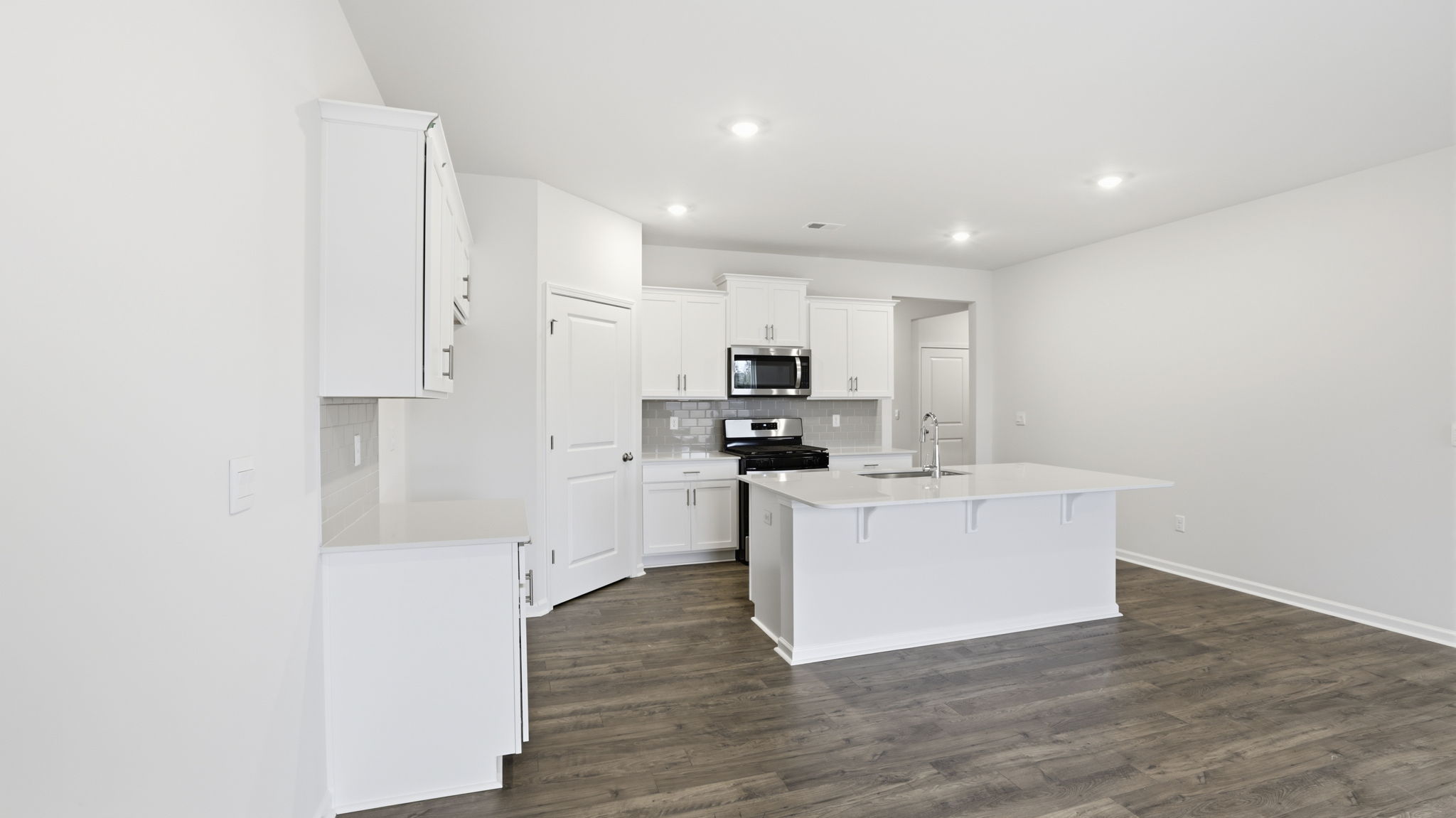 Kitchen open to the living area with recessed lighting.
