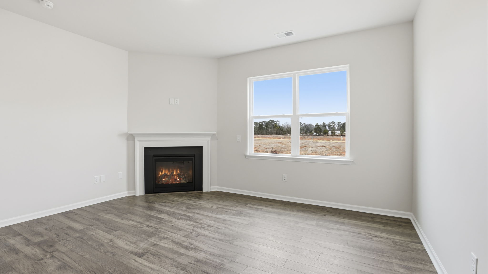 Family room with large windows and gas log fireplace.