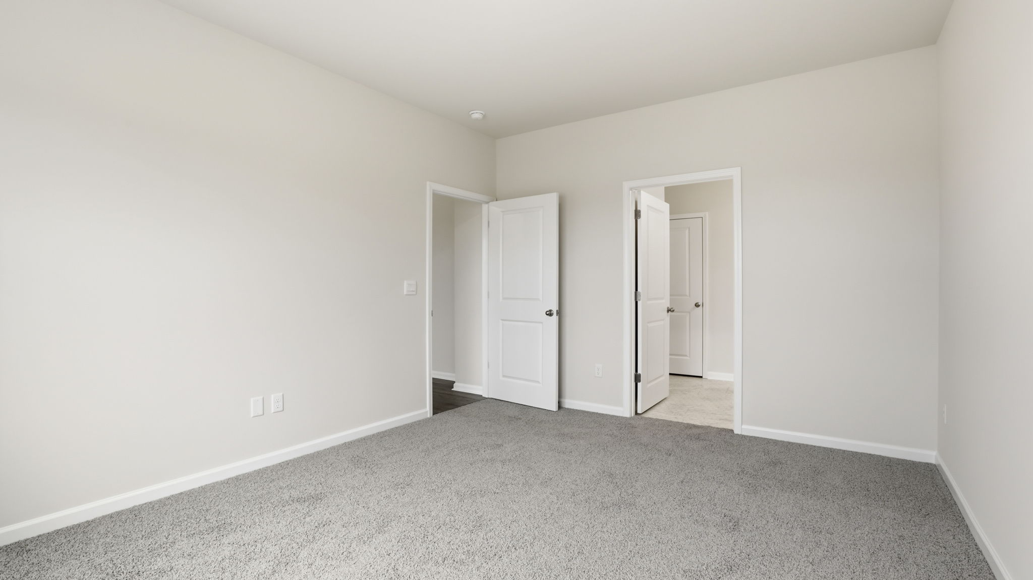 Primary bedroom with large window and carpet.