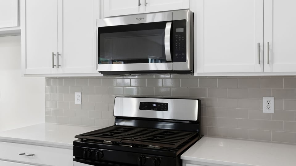 Close up of counter top with stove and microwave