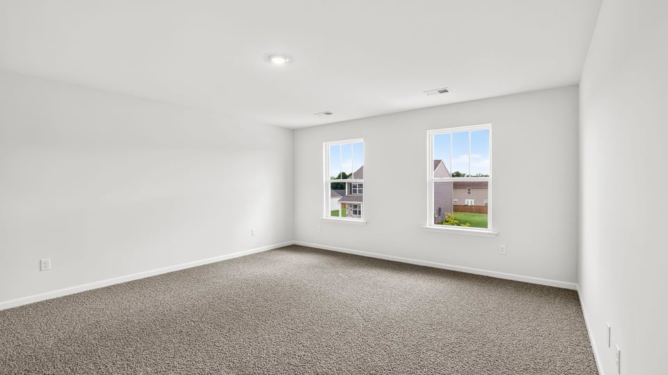 Primary bedroom with carpet and windows
