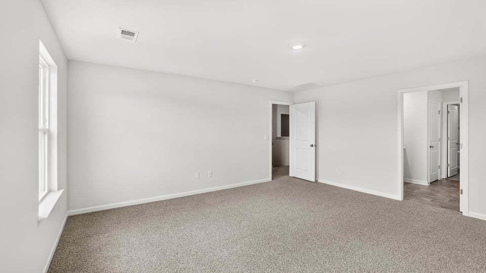 Primary bedroom with carpet and closet