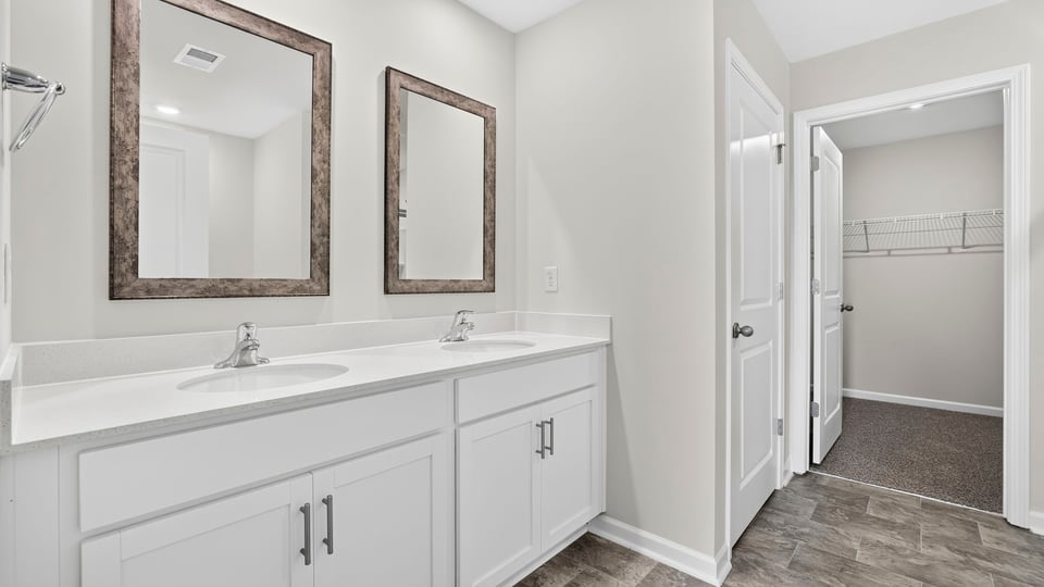 Primary bathroom with double vanity sink and closet