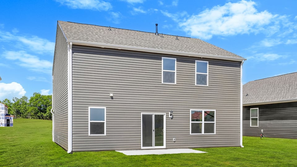 Back exterior of home with large backyard.