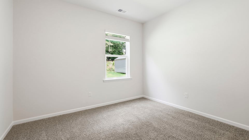 Bedroom with carpet and window.