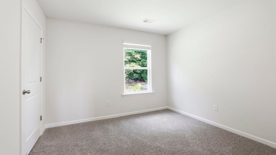 Bedroom with carpet and window.