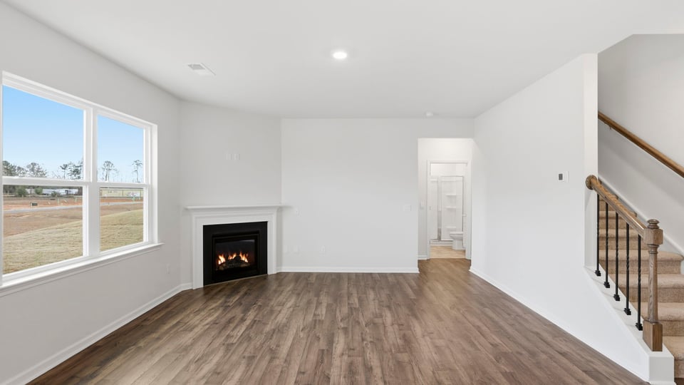 Family with large windows, gas log fireplace and recessed lilghting.