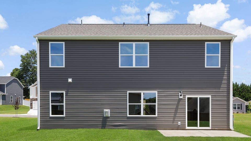 Back exterior of home with large baclkyard.