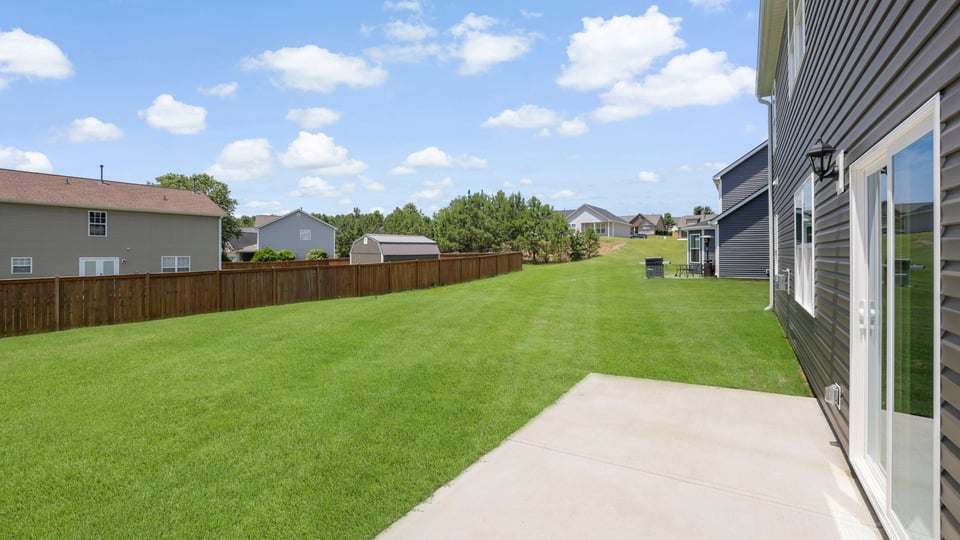 Back of home with patio.