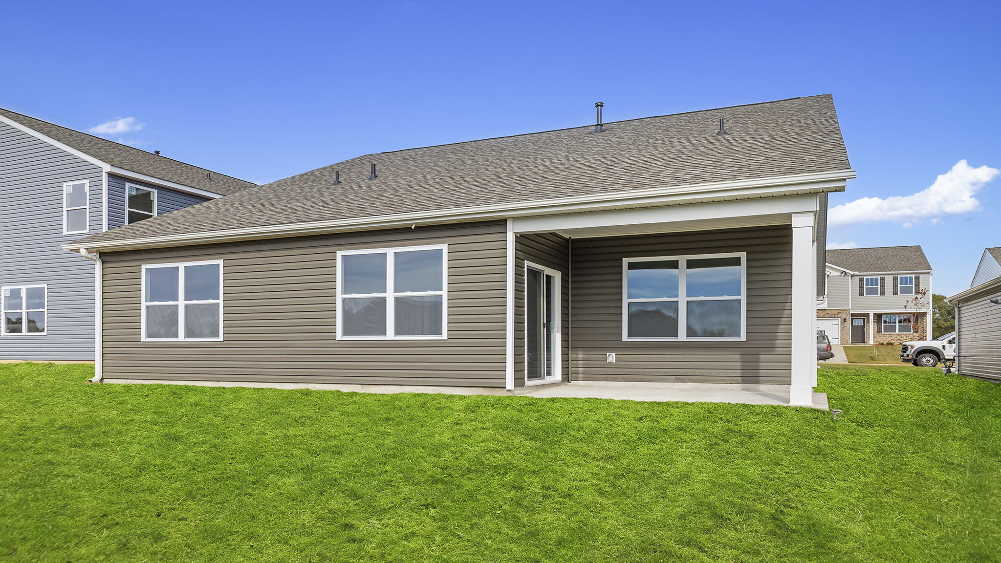 Back exterior with patio and large backyard.