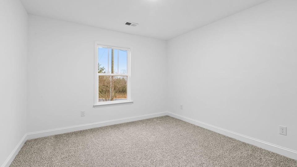 Bedroom with carpet and window.