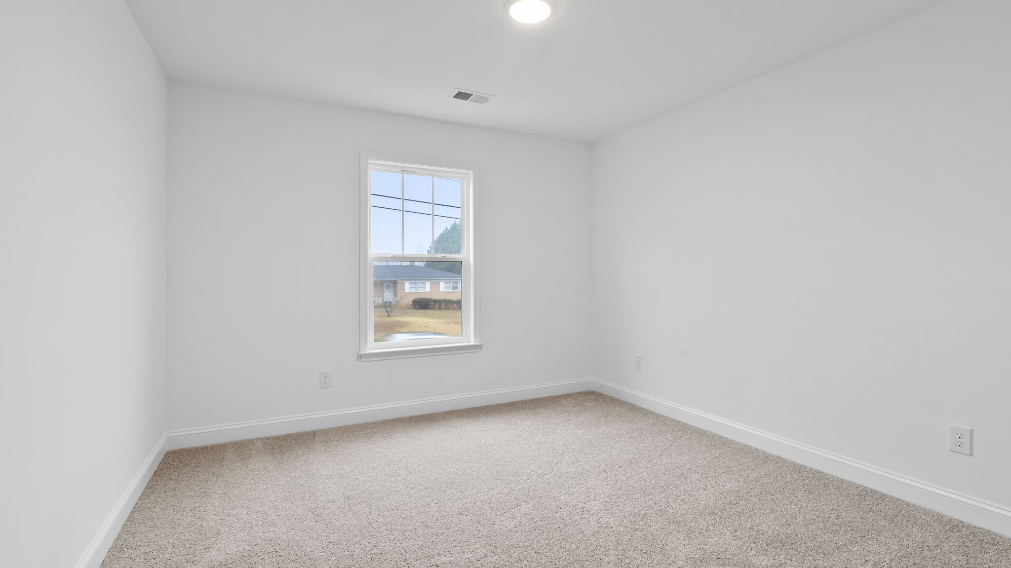 Bedroom with window and carpet.
