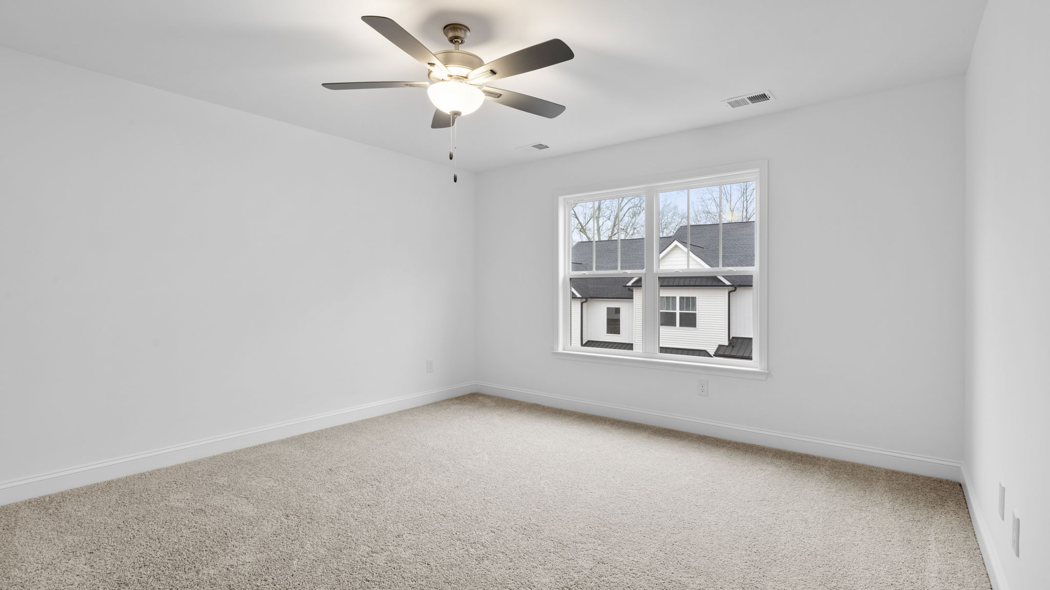Primary bedroom with large window and carpet.