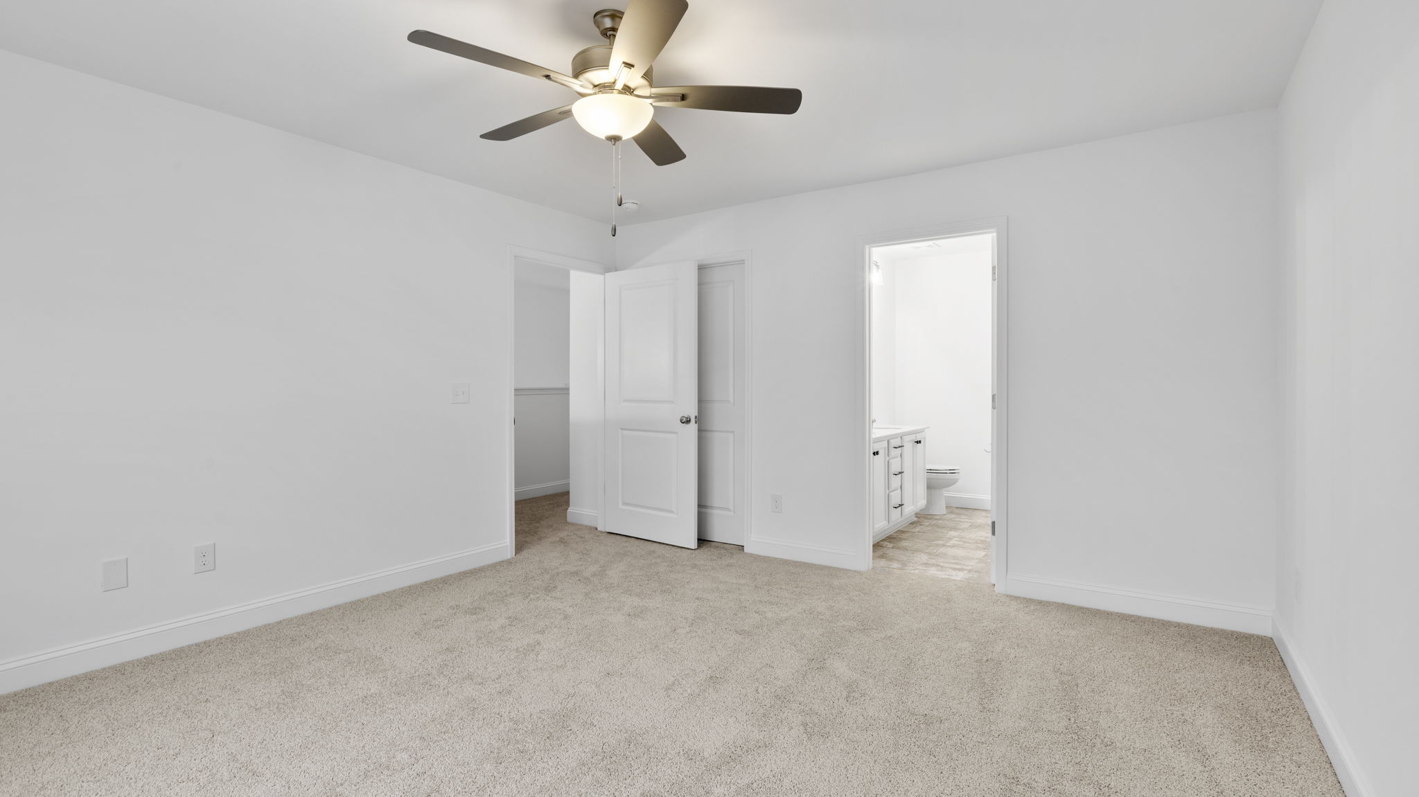 Primary bedroom with large window and carpet.
