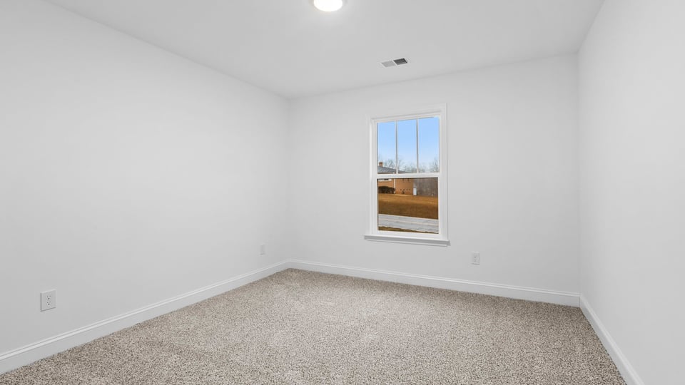 Bedroom with window and carpet.