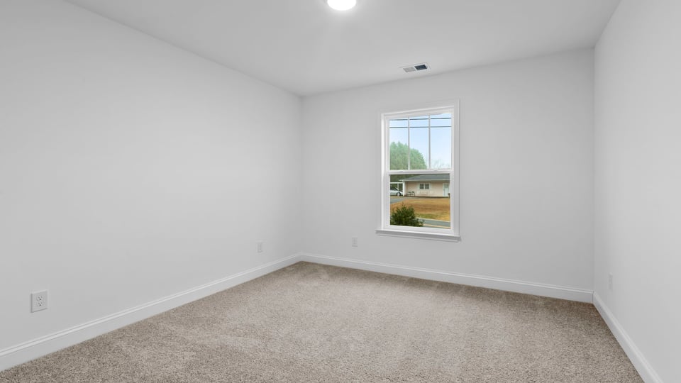 Bedroom with window and carpet.