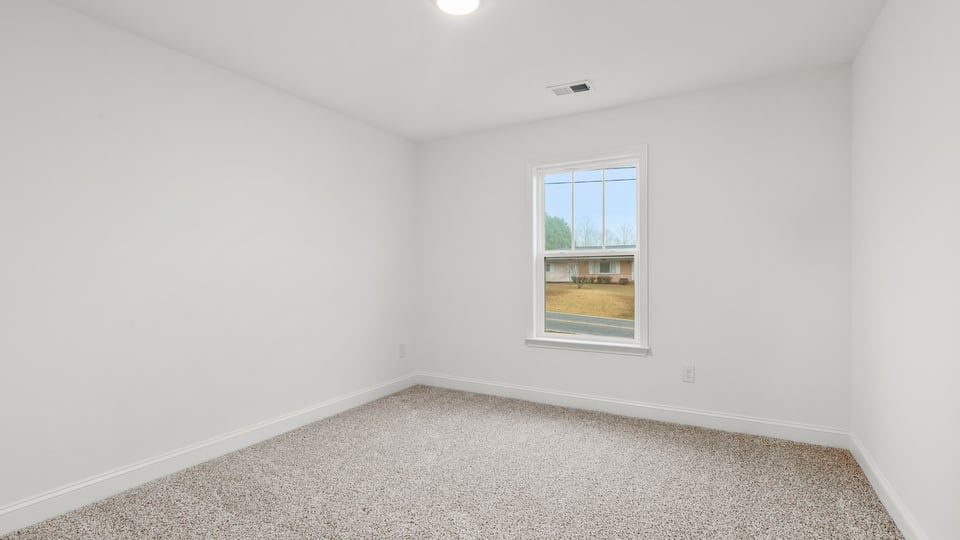Bedroom with window and carpet.