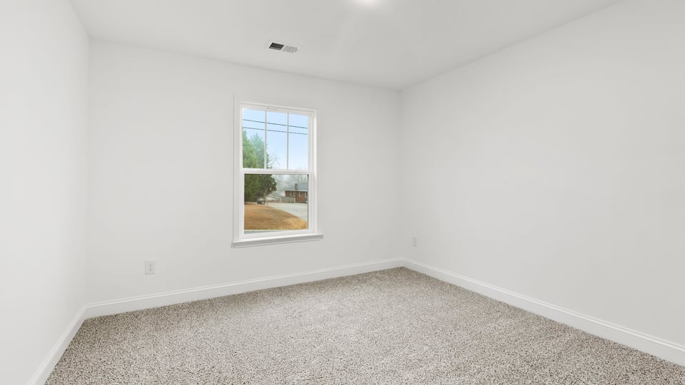 Bedroom with window and carpet.