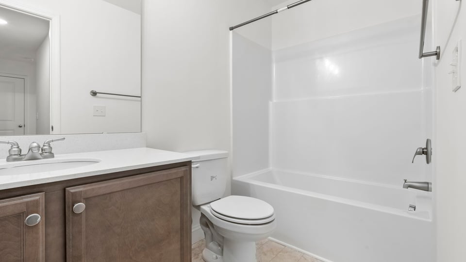 Hall bathroom with vanity and combination shower / tub.