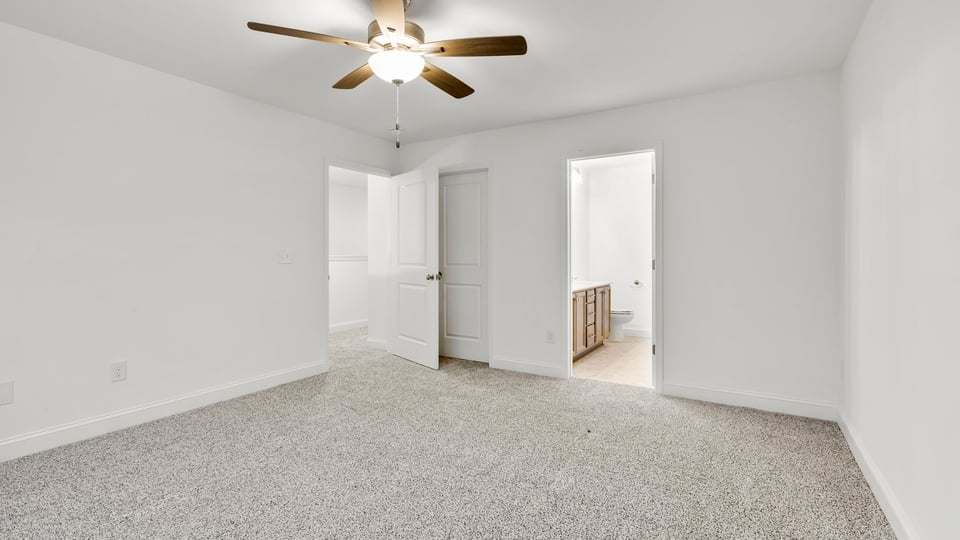 Primary bedroom with large window and carpet.