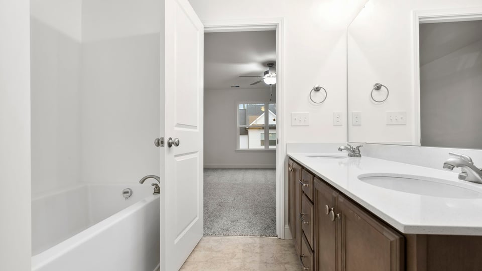 Primary bedroom with large window and carpet.