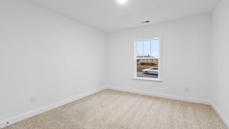 Bedroom with window and carpet.