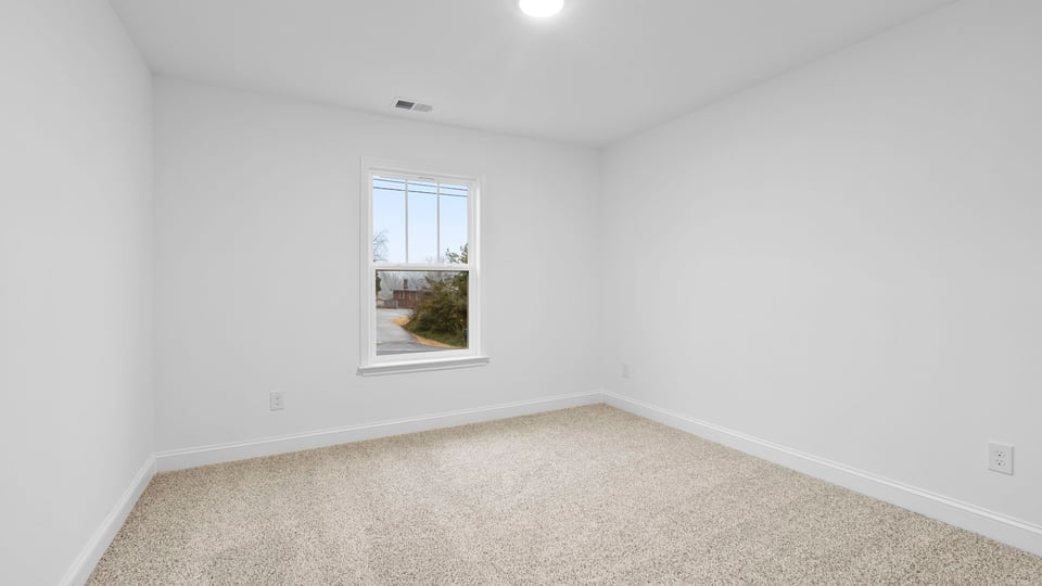 Bedroom with window and carpet.