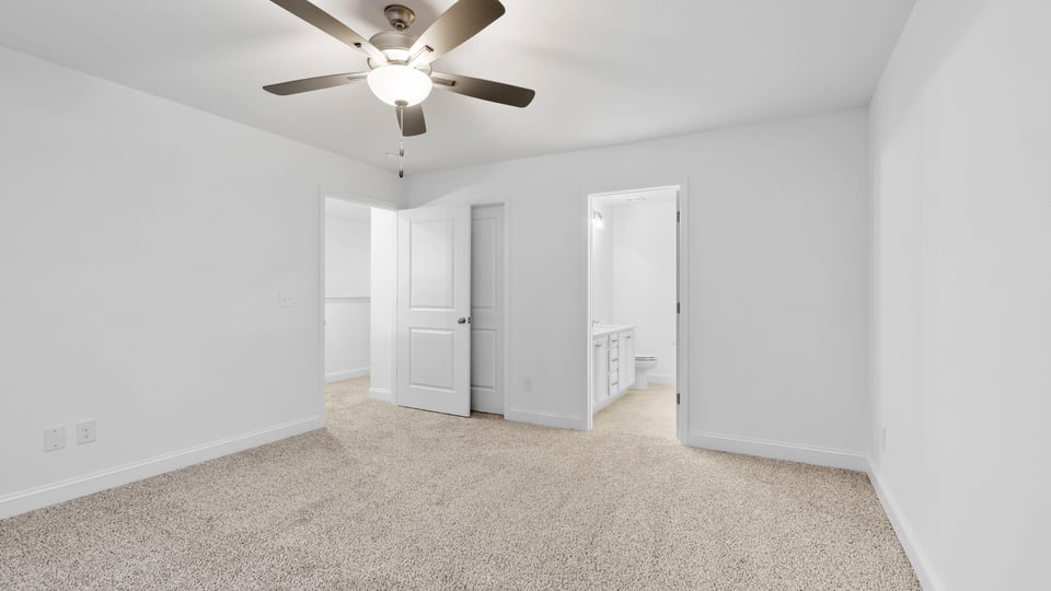 Primary bedroom with large window and carpet.