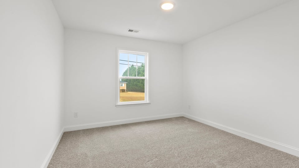 Bedroom with carpet and window.